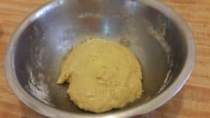 Homemade cinnamon buns dough in a bowl before rising.