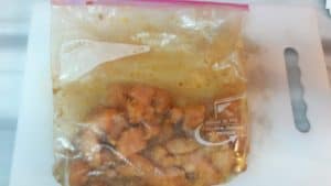 ziploc bag containing cut up chicken pieces and marinade.