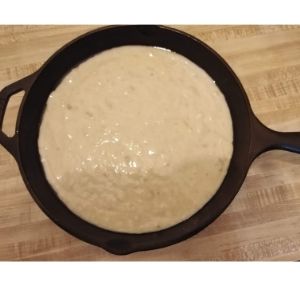 Pastella di pane alla banana in una padella di ghisa, pronta per cuocere.