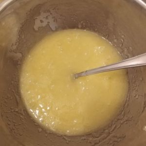 mixing bowl containing mixed eggs, oil, and sugar.